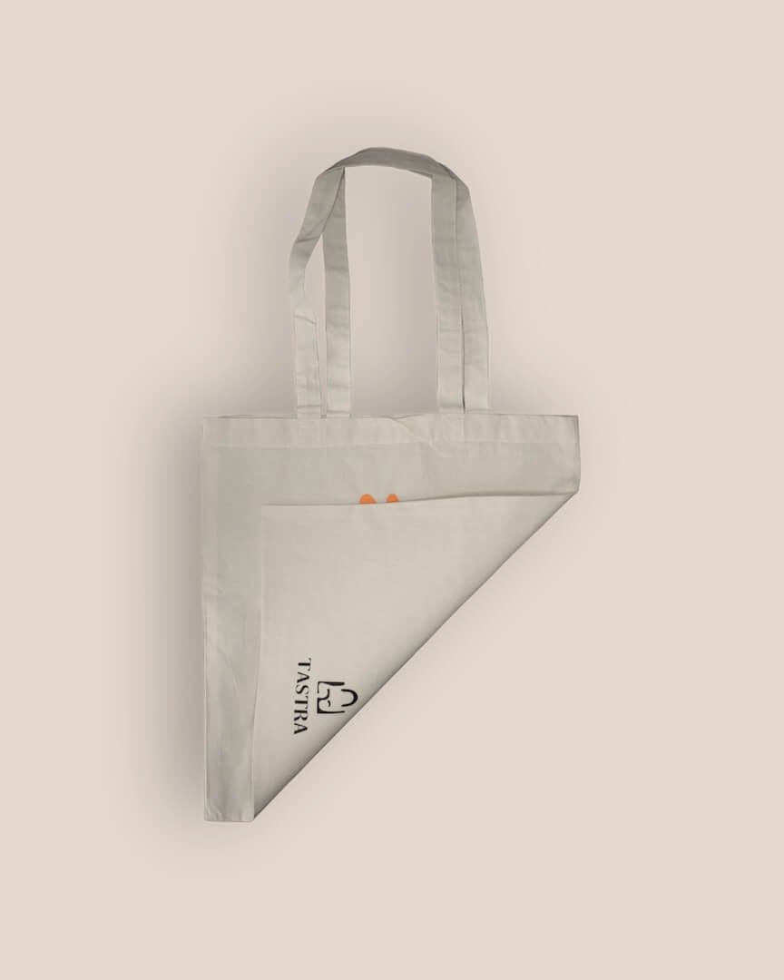 Achterzijde van Pluk De Dag Tote Bag toont Tastra-logo centraal onderaan, tas naar voren gevouwen