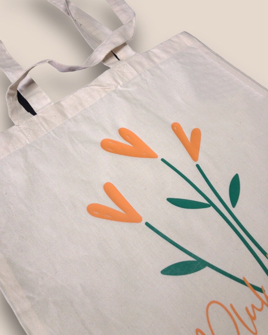 Close-up van 3 oranje, hartvormige bloemen en 'Pluk de dag' tekst op Pluk De Dag Tote Bag